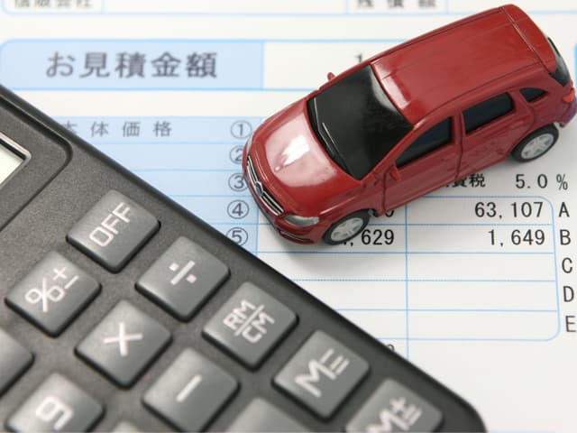 車のおもちゃと見積書と電卓